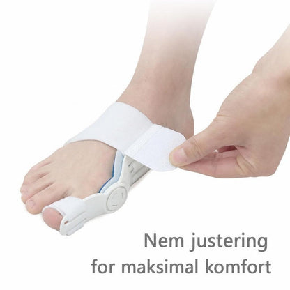 Fod med hvid hallux valgus-støtte, mens stroppen justeres med hånden