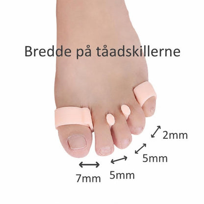 Fod med lyserøde tåspredere og angivne afstande på 2, 5 og 7 mm