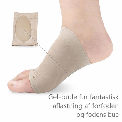 Beige fodstrømpe med gelpude under fodbuen på en fod