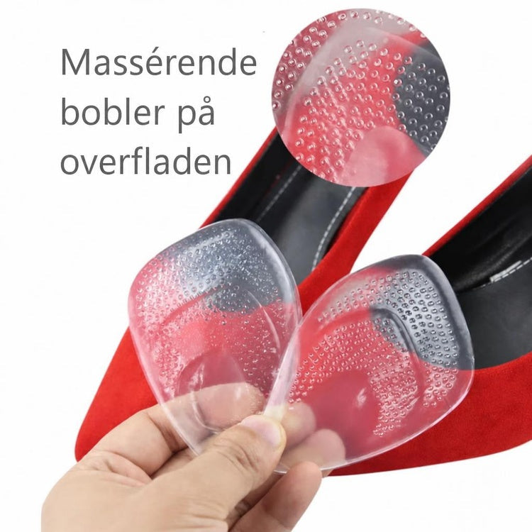 Gennemsigtige silikone-forfodsindlæg med boblet overflade foran røde højhælede sko