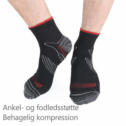 Sorte ankelstrømper med røde kanter og grå mønstre på fødder