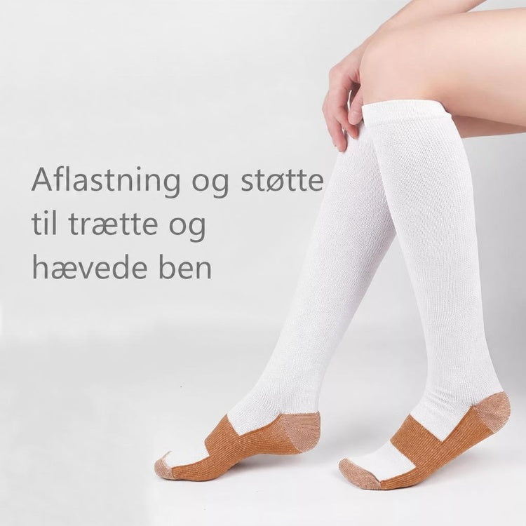 Hvide og brune knælange støttestrømper på ben