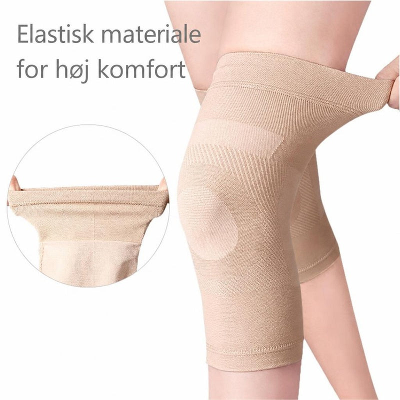 Beige elastisk knæstøtte på knæ, trukket ud for at vise materialet