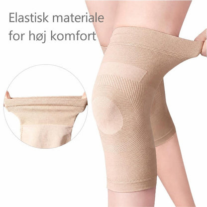 Beige elastisk knæstøtte på knæ, trukket ud for at vise materialet