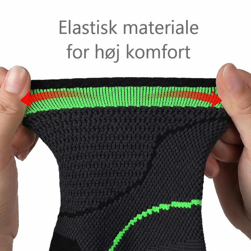 Sort og grønt ankelstøtte i elastisk materiale strækkes mellem hænder