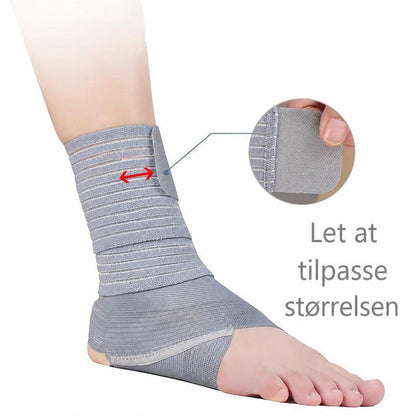 Grå elastisk ankelstøtte med justerbare bånd på en fod