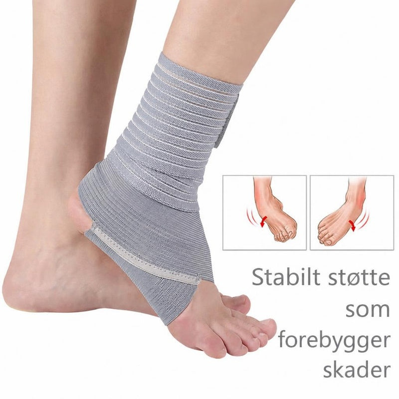 Grå elastisk ankelstøtte med rem omkring fod og ankel