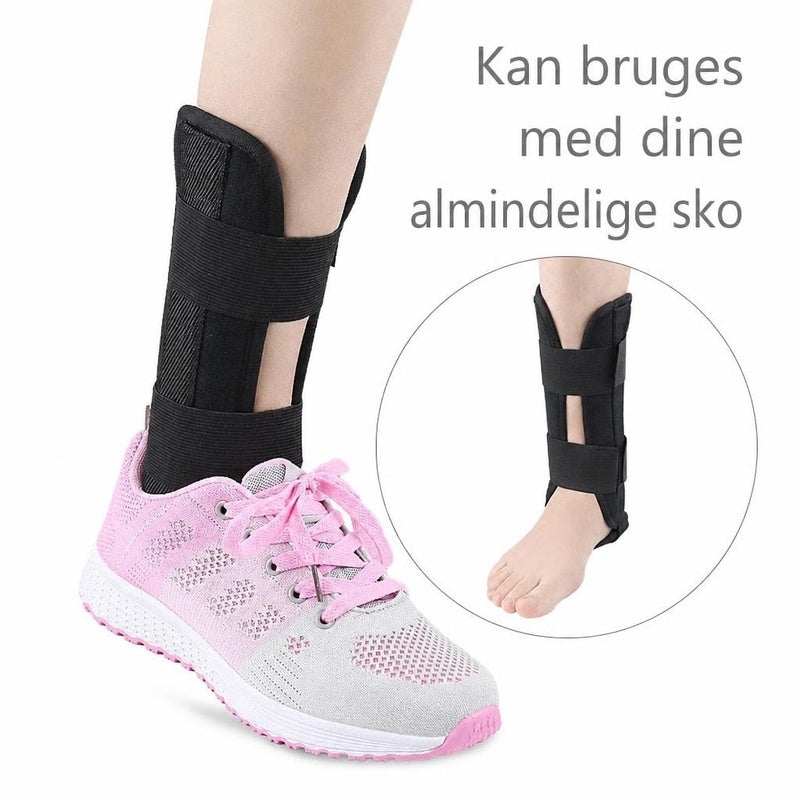 Sort stabiliserende ankelstøtte med skinner, vist med pink sportssko