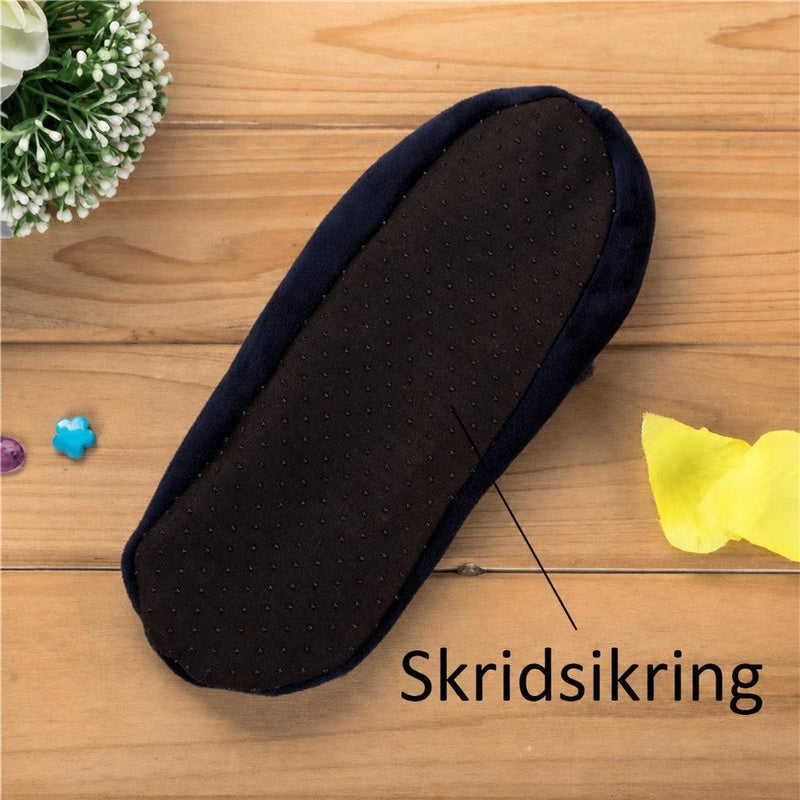 Blå hjemmesko med sort skridsikker sål på træbord