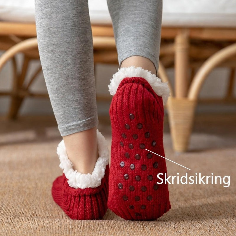 Røde strikkede tøfler med hvidt for og skridsikre prikker under sålen