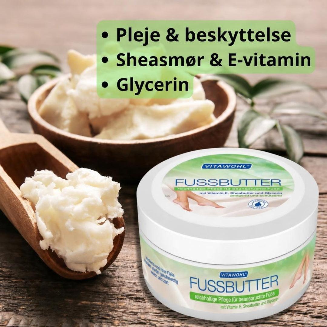 Vitawohl Fussbutter fodcreme i hvid krukke med sheasmør på træbord