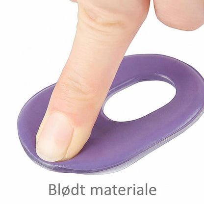 Finger trykker på lilla gelplaster med hul i midten