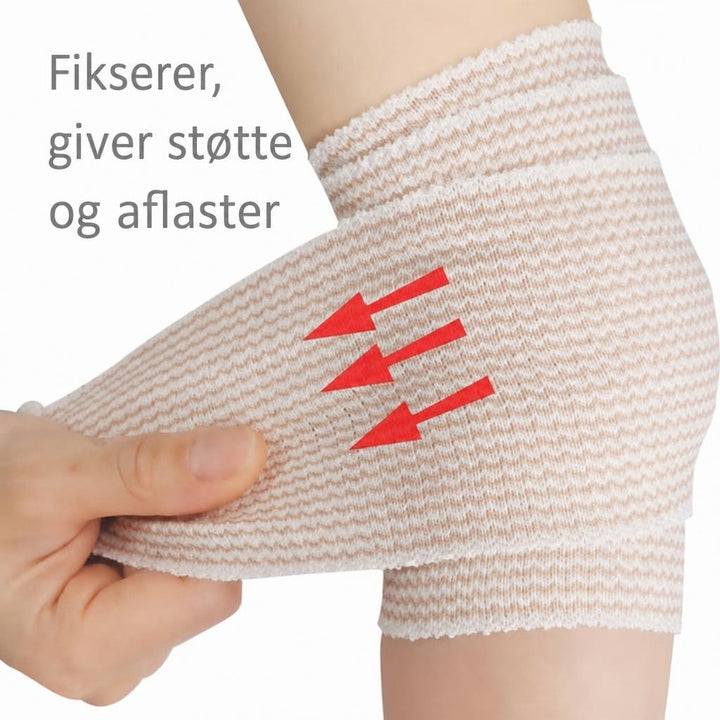 Elastisk støttebind viklet om ankel og hæl med hånd der strammer