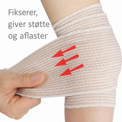 Elastisk støttebind viklet om ankel og hæl med hånd der strammer