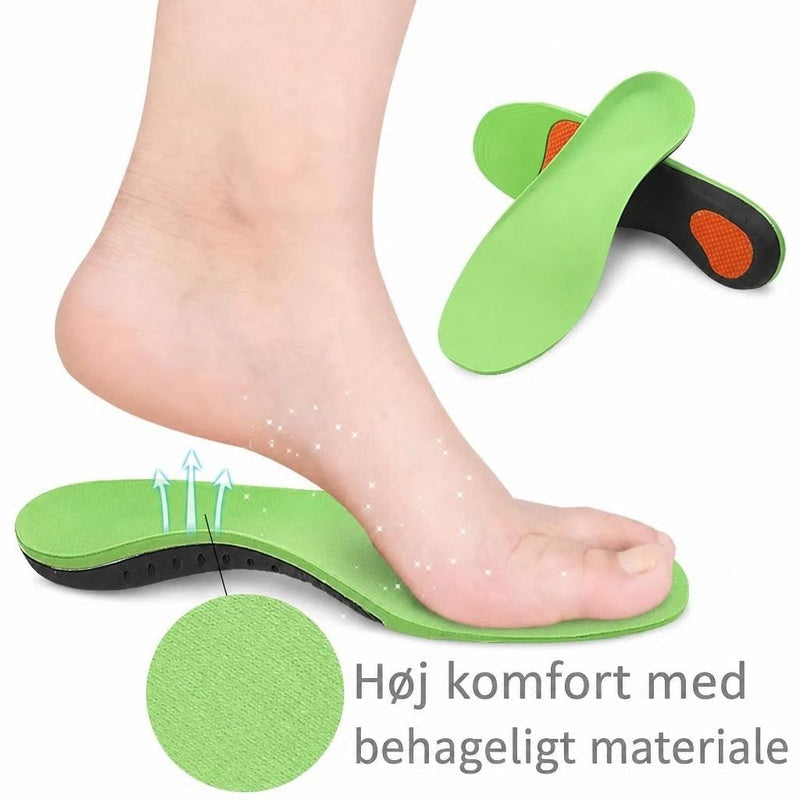 Grøn sportssål under en fod med ekstra indlægssåler i baggrunden