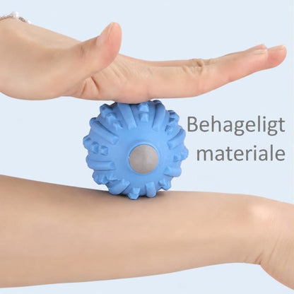 Blå massagebold med pigge presset mod fodsål og underben