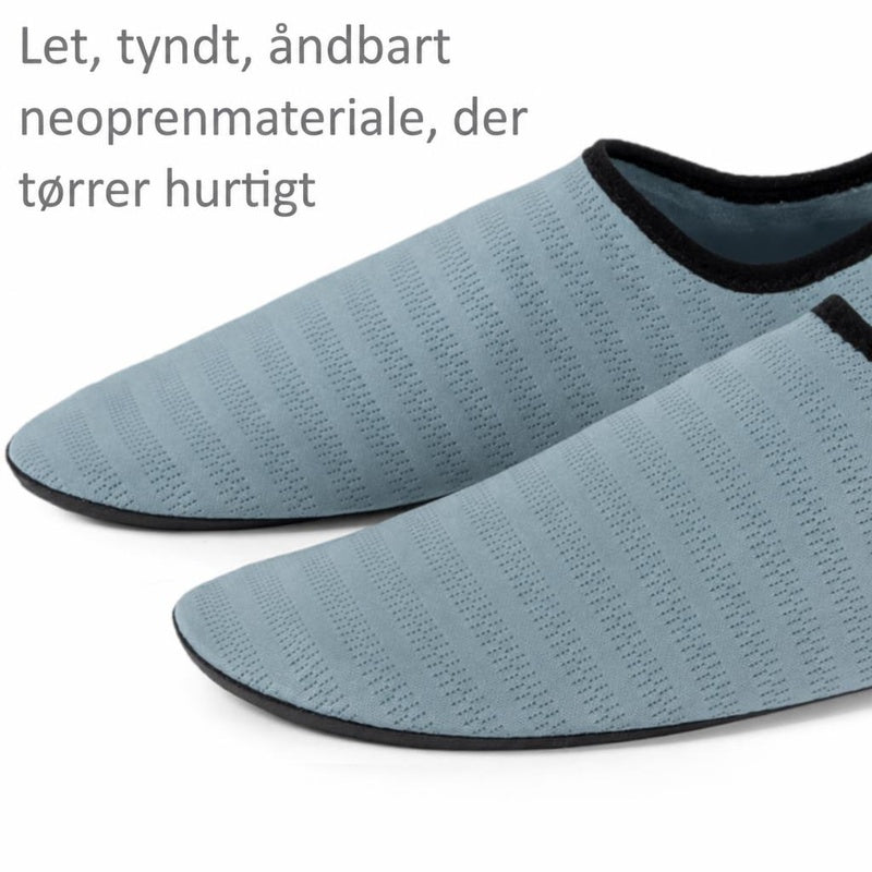 Turkise badesko i neopren med sort kant og tekstureret overflade