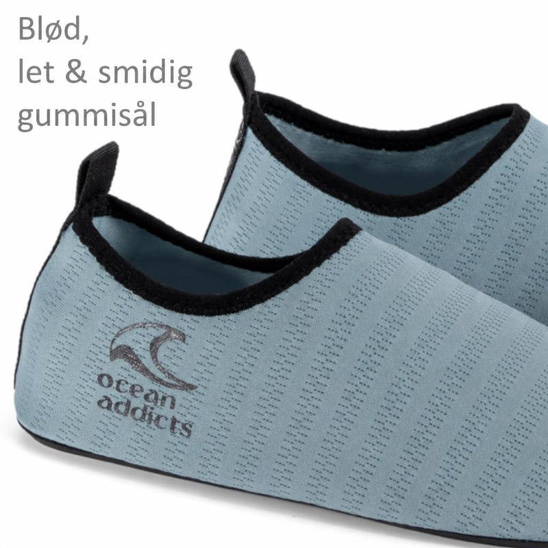 Turkise badesko med sort kant, hælstropper og Ocean Addicts-logo