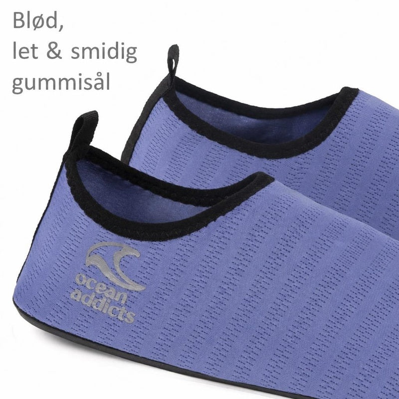 Lavendelfarvede badsko med sort kant og tekst om fleksibel gummisål