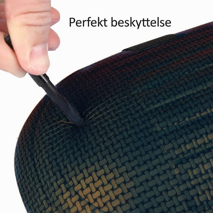 Sort tekstureret knæbeskytter presses ned med en skruetrækker