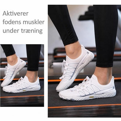 Hvide barfodssko med grå detaljer på løbebånd med sorte leggings