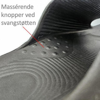 Sort tøffel med rillet indersål og knopper ved svangstøtten