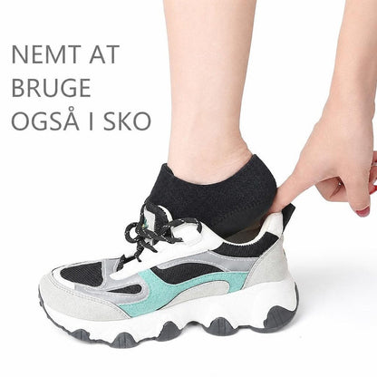 Sort hælstøtte på fod, der sættes ned i en sneaker