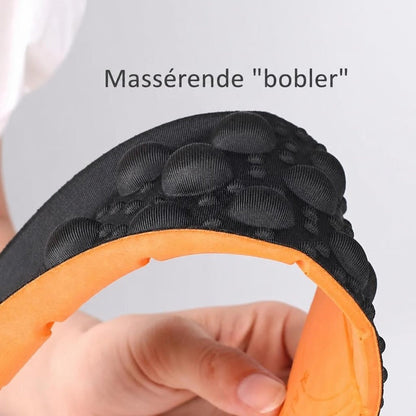 Bøjet skoinlæg med sorte masserende bobler og orange underside