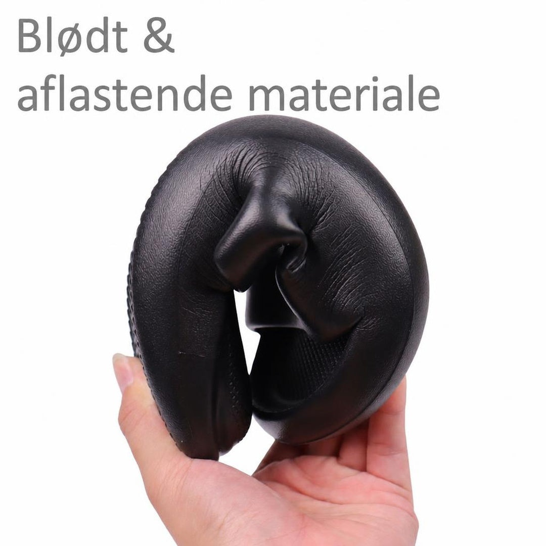 Sort Bounce-tøffel bøjet sammen i en hånd for at vise fleksibelt materiale