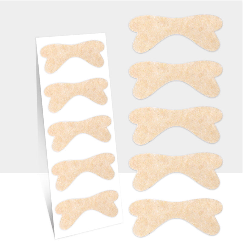 Beige nageltrångstejp i böjd form på ark och löst placerad
