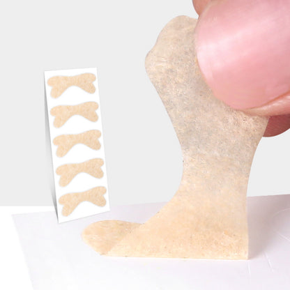 Beige nageltrångstejp løftes fra et ark med flere strips