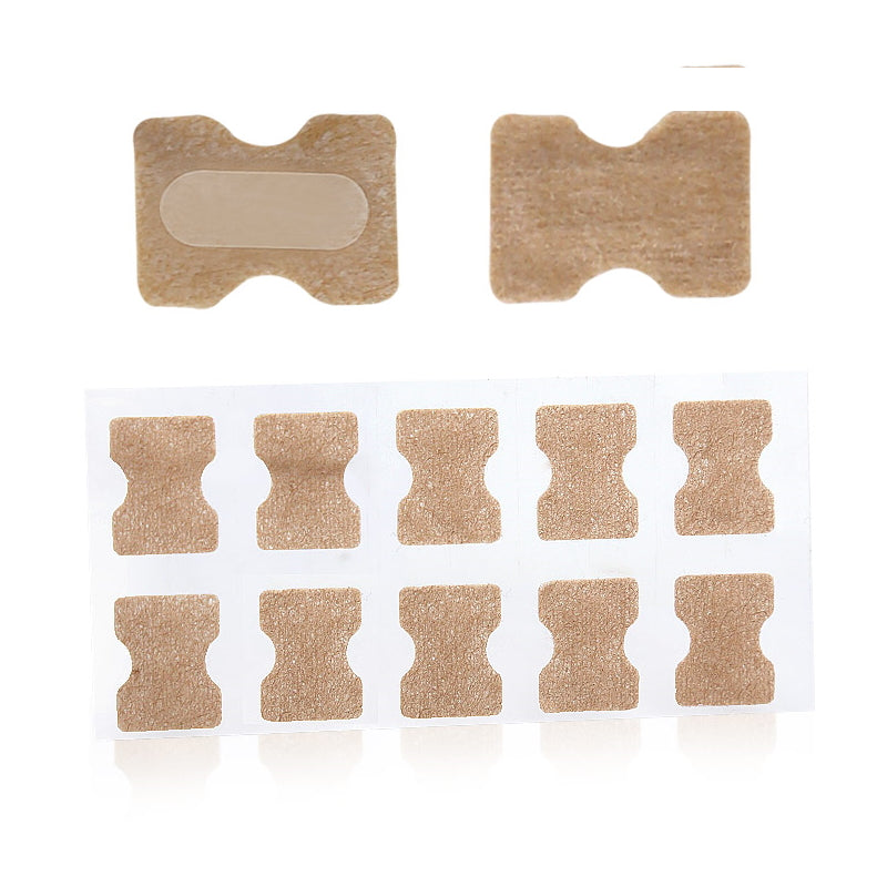 Beige korrigerende negletape i timeglasform på hvidt ark