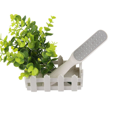 Hvid dobbeltsidet fodfil med grå slibeflade ved grøn plante