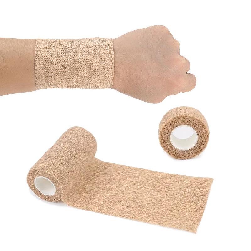 Beige elastisk bandagetape på håndled med to ruller ved siden af