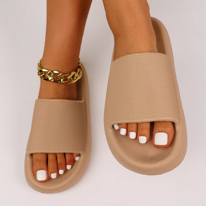 Beige slippers med bred rem, åben tå og guldfarvet ankelkæde