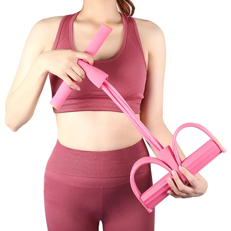Kvinde i træningstøj holder et pink multifunktionelt træningselastik