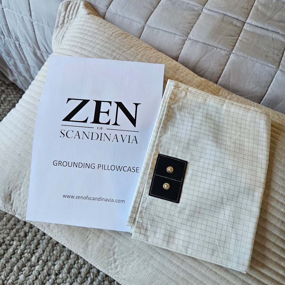 Foldet jordningspudebetræk fra Zen of Scandinavia med brochure på seng
