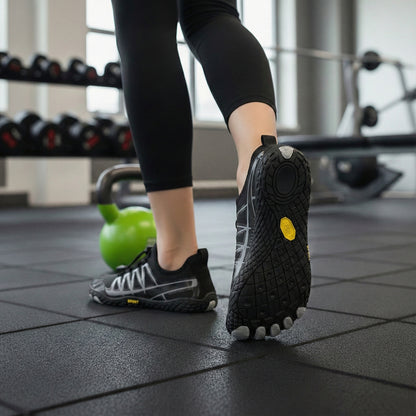 Sorte barfodssko med tåformet sål på træningsgulv i fitnesscenter
